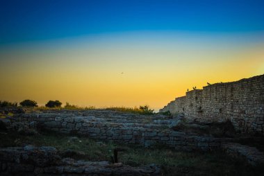 Antik kale duvarının üzerinde gün batımı gökyüzü