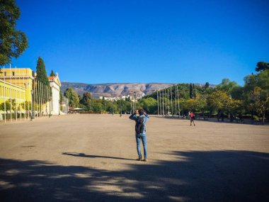 Genç adam gündüz manzaranın fotoğrafını çekiyor.