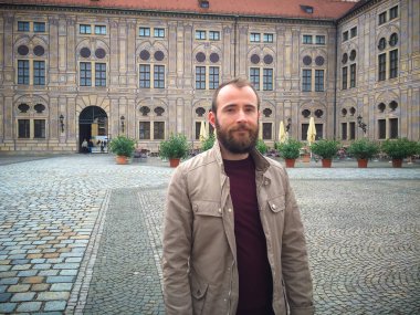 Bir binanın avlusundaki bir adamın portresi.