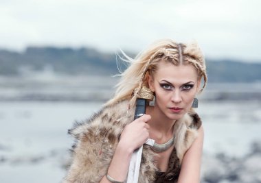 Onun elinde bir kılıç ile bir kurt derideki bir savaşçı kızdır. Vikingler bir kadın. Ortaçağ Avrupa sahne yeniden inşası.