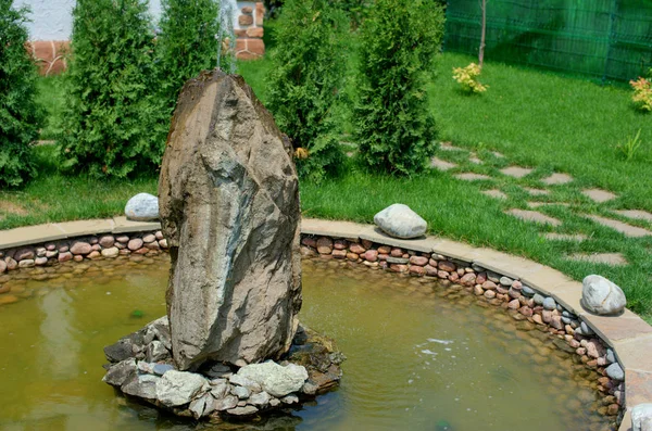 An artificial garden fountain in the form of a rock with a large bowl