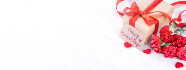 Mayıs anneler gün kavramı el yapımı giftbox fikir Fotoğrafçılık dilek-modern mermer masada izole kırmızı şerit yay kutusu ile güzel çiçeklenme karanfil, yakın çekim, kopya alanı, alay