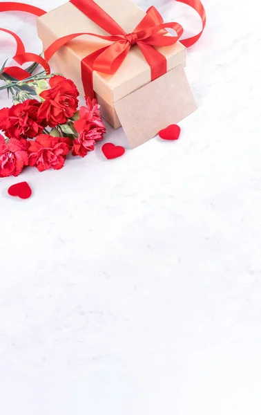 El concepto del día de las madres de mayo idea de caja de regalo hecha a mano desea fotografía: hermosos claveles florecientes con caja de lazo de cinta roja aislada en el escritorio de mármol moderno, primer plano, espacio para copiar, burlarse —  Fotos de Stock