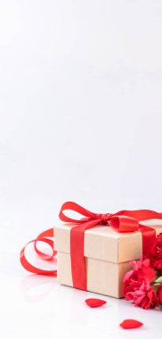 El yapımı giftbox fotoğrafçılık - modern mermer masasında izole kırmızı şerit yay kutusuyla güzel çiçek açan karanfil dilek Mayıs Anneler günü yakın çekim, uzay kopyalayın, yukarı alay
