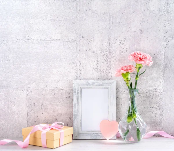 Close up, copy space, mock up, beautiful mothers day event concept handmade giftbox decoration photography, blooming fresh carnations with pink color ribbon isolated on gray wallpaper — Stock Photo, Image