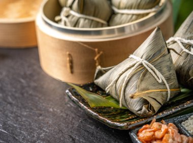 Yakın çekim, kopya alanı, Dragon Boat (Duan Wu) festivalinde ünlü Asya lezzetli el yapımı gıda, buharda buharda pirinç köfte şeklinde piramit yaprakları malzemeler tarafından sarılmış taze