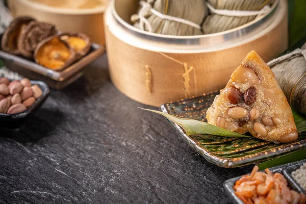 Close up, espaço de cópia, famoso asiático saboroso comida artesanal em dragão barco (duan wu) festival, fresco a partir de vapor bolinhos de arroz em forma de pirâmide embrulhado por folhas ingredientes — Fotografia de Stock