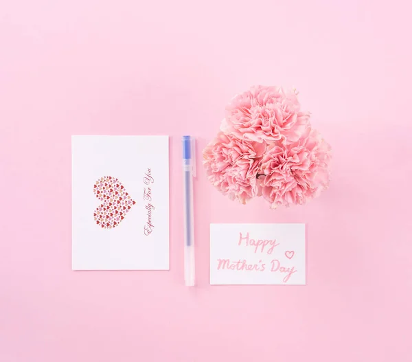 Top view, flat lay, mock up, copy space, handwritten greeting card template isolated with pale pink background, idea concept of thanks, wishes, craft carnations bouquet — Stock Photo, Image