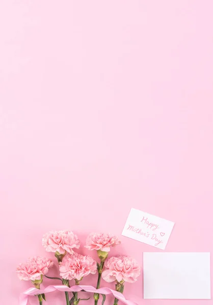 평면도, 평 신도, 모의 업, 복사 공간, 창백한 분홍색 배경으로 고립 된 필기 인사말 카드 템플릿, 감사의 아이디어 개념, 소원, 공예 카네이션 부케 — 스톡 사진