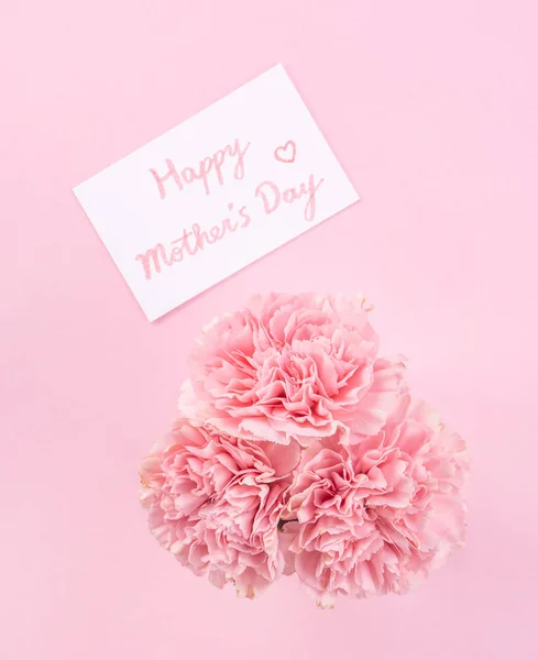 Top view, flat lay, mock up, copy space, handwritten greeting card template isolated with pale pink background, idea concept of thanks, wishes, craft carnations bouquet — Stock Photo, Image