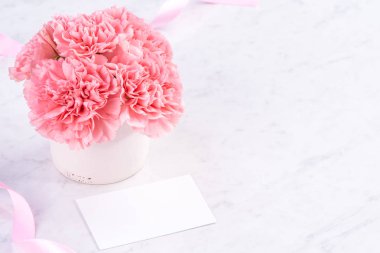 Alanı kopyala, kapat, alay et, yolu kırp. Anneler günü ifade konsept tasarımı. Parlak mermer arka plan üzerinde izole güzel taze çiçekbebek pembe renk karanfiller.