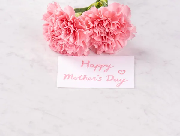 Copy space, close up, mock up, clipping path. Mothers day wording concept design. Beautiful fresh blooming baby pink color carnations isolated on bright marble background. — Stock Photo, Image