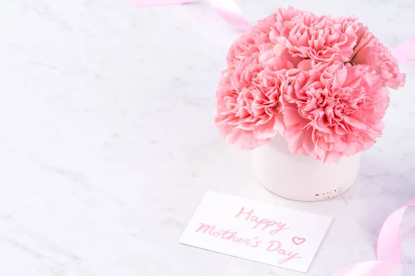 Copy space, close up, mock up, clipping path. Mothers day wording concept design. Beautiful fresh blooming baby pink color carnations isolated on bright marble background. — Stock Photo, Image