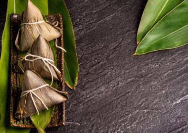 Kapat, kopya alanı, üst görünüm, düz yatıyordu. Duan Wu olay ünlü asya çin lezzetli el yapımı gıda, siyah kayrak üzerinde piramit madde şeklinde buğulanmış pirinç köfte