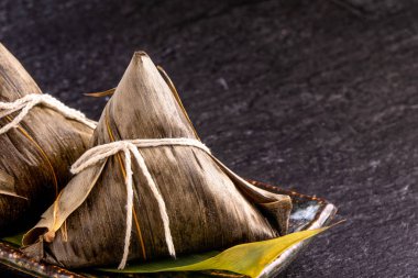Kapat, kopya alanı, üst görünüm, düz yatıyordu. Duan Wu olay ünlü asya çin lezzetli el yapımı gıda, siyah kayrak üzerinde piramit madde şeklinde buğulanmış pirinç köfte