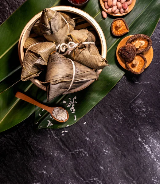 Close up, espaço de cópia, vista superior, flat lay. Famoso asiático chinês saboroso comida artesanal em duan wu evento, bolinhos de arroz cozido no vapor em forma de ingrediente piramidal na ardósia preta — Fotografia de Stock