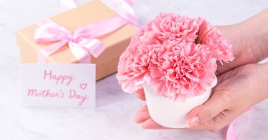 Tasarım konsepti - Kadın mermer beyaz arka plan, üst görünüm, kopya alanı, yakın, alay üzerine karanfil buket veren. Anneler günü fikir ilham.