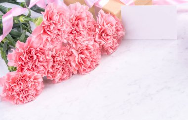 Tasarım konsepti - Mermer beyaz arka plan üzerinde karanfil Güzel demet, üst görünüm, kopya alanı, yakın, alay. Anneler günü hediye fikir ilham.