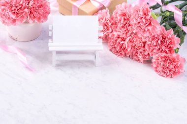 Tasarım konsepti - Mermer beyaz arka plan üzerinde karanfil Güzel demet, üst görünüm, kopya alanı, yakın, alay. Anneler günü hediye fikir ilham.