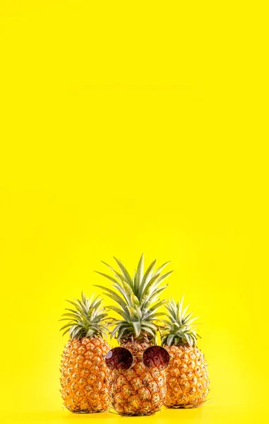 Креативное сосновое яблоко с солнцезащитными очками и оболочкой, изолированной на желтом фоне, дизайн идеи пляжа для летнего отдыха, пространство для копирования крупным планом — стоковое фото