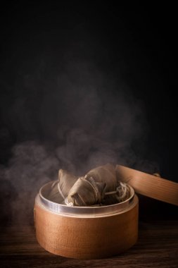 Zongzi, buharda pişirilmiş pirinç köfteleri ahşap masada, ejderha teknesi festivalinde lezzetli yemekler duanwu tasarım konsepti, kapat, uzayı kopyala.