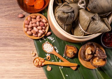 Zongzi, ahşap masa bambu yaprakları üzerinde buğulanmış pirinç köftesi, ejderha teknesi festivali Duanwu konseptinde yemek, kapan, kopyalama alanı, üst görünüm, düz yatış