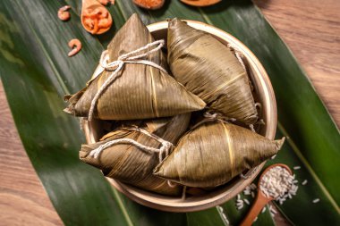 Zongzi, ahşap masa bambu yaprakları üzerinde buğulanmış pirinç köftesi, ejderha teknesi festivali Duanwu konseptinde yemek, kapan, kopyalama alanı, üst görünüm, düz yatış