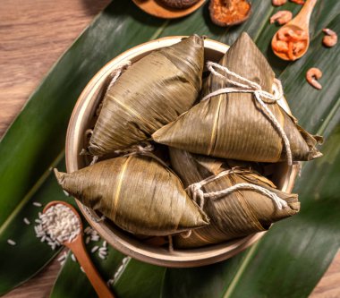 Zongzi, ahşap masa bambu yaprakları üzerinde buğulanmış pirinç köftesi, ejderha teknesi festivali Duanwu konseptinde yemek, kapan, kopyalama alanı, üst görünüm, düz yatış