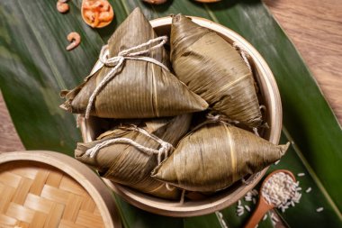 Zongzi, ahşap masa bambu yaprakları üzerinde buğulanmış pirinç köftesi, ejderha teknesi festivali Duanwu konseptinde yemek, kapan, kopyalama alanı, üst görünüm, düz yatış