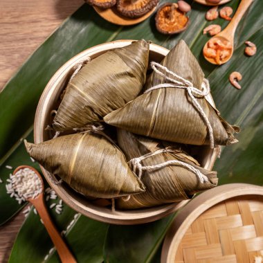 Zongzi, ahşap masa bambu yaprakları üzerinde buğulanmış pirinç köftesi, ejderha teknesi festivali Duanwu konseptinde yemek, kapan, kopyalama alanı, üst görünüm, düz yatış