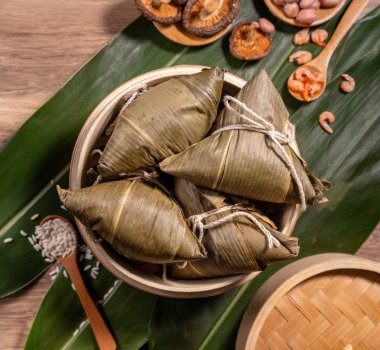 Zongzi, ahşap masa bambu yaprakları üzerinde buğulanmış pirinç köftesi, ejderha teknesi festivali Duanwu konseptinde yemek, kapan, kopyalama alanı, üst görünüm, düz yatış