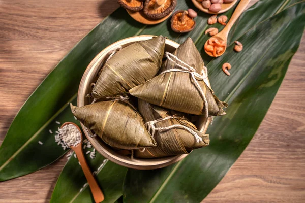 Zongzi, ahşap masa bambu yaprakları üzerinde buğulanmış pirinç köftesi, ejderha teknesi festivali Duanwu konseptinde yemek, kapan, kopyalama alanı, üst görünüm, düz yatış