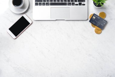 İş finansal tasarım konsepti, akıllı telefon ile mermer beyaz ofis masa masa üst görünümü, mockup kredi kartı, sikke, dizüstü bilgisayar, düz yatıyordu, kopyalama alanı