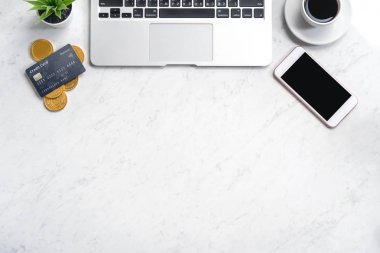 İş finansal tasarım konsepti, akıllı telefon ile mermer beyaz ofis masa masa üst görünümü, mockup kredi kartı, sikke, dizüstü bilgisayar, düz yatıyordu, kopyalama alanı
