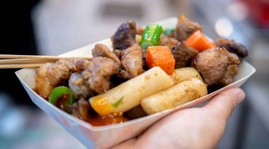 Kore geleneksel pazarda tavada siyah domuz yemeği, havuç ve arpacık yeşil soğan ile lezzetli Kore gıda mutfağı, yakın, kopya alanı