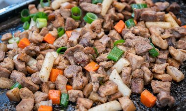 Kore geleneksel pazarda tavada siyah domuz yemeği, havuç ve arpacık yeşil soğan ile lezzetli Kore gıda mutfağı, yakın, kopya alanı