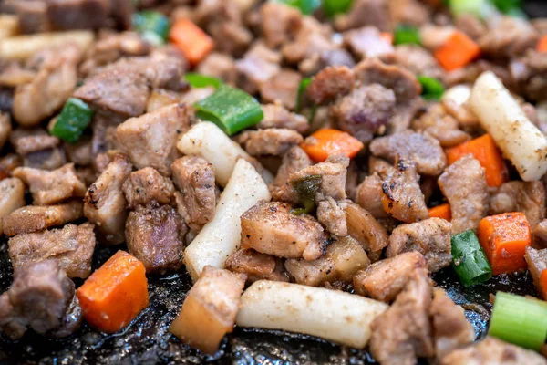 Masakan babi hitam goreng di pasar tradisional Korea, masakan Korea yang lezat dengan wortel dan bawang bombay hijau, tutup, menyalin ruang — Stok Foto