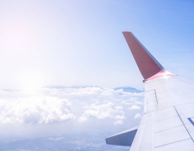 Bussiness ve seyahat konsepti. Güneş ışığı ile güzel mavi gökyüzü ve bulut ile uçak kabin içinde pencereden havadan görünümü, kopya alanı, üst görünüm