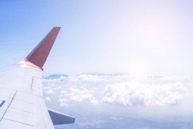 Bussiness ve seyahat konsepti. Güneş ışığı ile güzel mavi gökyüzü ve bulut ile uçak kabin içinde pencereden havadan görünümü, kopya alanı, üst görünüm