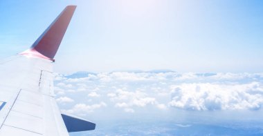 Bussiness ve seyahat konsepti. Güneş ışığı ile güzel mavi gökyüzü ve bulut ile uçak kabin içinde pencereden havadan görünümü, kopya alanı, üst görünüm