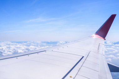 Bussiness ve seyahat konsepti. Güneş ışığı ile güzel mavi gökyüzü ve bulut ile uçak kabin içinde pencereden havadan görünümü, kopya alanı, üst görünüm