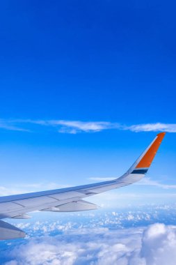 Bussiness ve seyahat konsepti. Güneş ışığı ile güzel mavi gökyüzü ve bulut ile uçak kabin içinde pencereden havadan görünümü, kopya alanı, üst görünüm