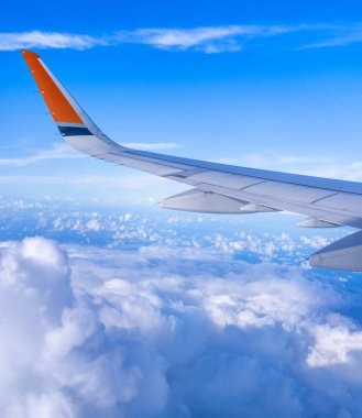 Bussiness ve seyahat konsepti. Güneş ışığı ile güzel mavi gökyüzü ve bulut ile uçak kabin içinde pencereden havadan görünümü, kopya alanı, üst görünüm