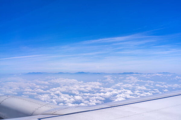 Bussiness and travel concept. Aerial view through window inside aircraft cabin with beautiful blue sky and cloud with sunlight, copy space, top view