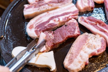 Kore restoranında tavada siyah domuz yemeği, marul ile demir tabakta taze lezzetli Kore yemekleri mutfağı, yakın çekim, kopya alanı, yaşam tarzı