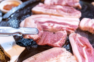 Kore restoranında tavada siyah domuz yemeği, marul ile demir tabakta taze lezzetli Kore yemekleri mutfağı, yakın çekim, kopya alanı, yaşam tarzı