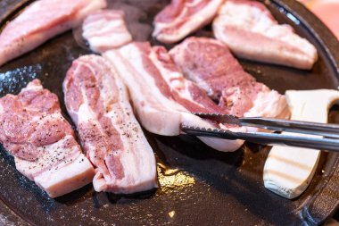 Kore restoranında tavada siyah domuz yemeği, marul ile demir tabakta taze lezzetli Kore yemekleri mutfağı, yakın çekim, kopya alanı, yaşam tarzı