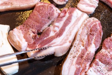 Kore restoranında tavada siyah domuz yemeği, marul ile demir tabakta taze lezzetli Kore yemekleri mutfağı, yakın çekim, kopya alanı, yaşam tarzı