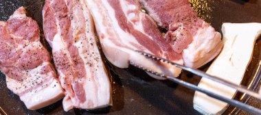 Kore restoranında tavada siyah domuz yemeği, marul ile demir tabakta taze lezzetli Kore yemekleri mutfağı, yakın çekim, kopya alanı, yaşam tarzı