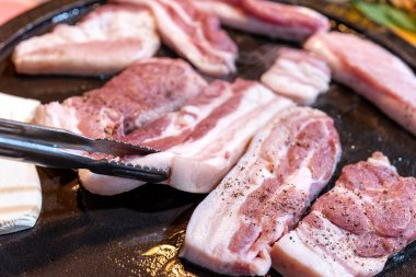 Kore restoranında tavada siyah domuz yemeği, marul ile demir tabakta taze lezzetli Kore yemekleri mutfağı, yakın çekim, kopya alanı, yaşam tarzı